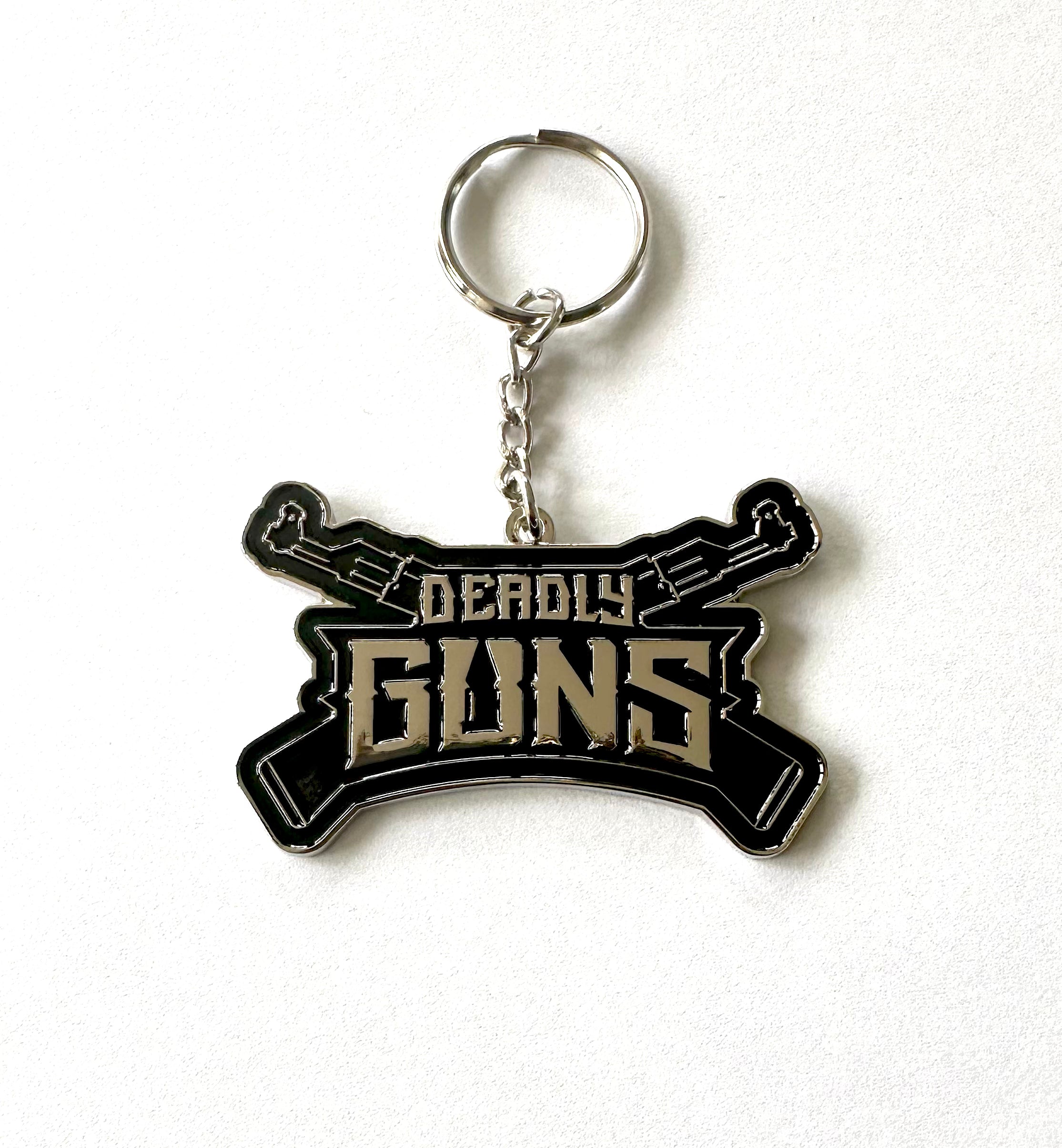 Keychain with 'Deadly Guns' text on a white background